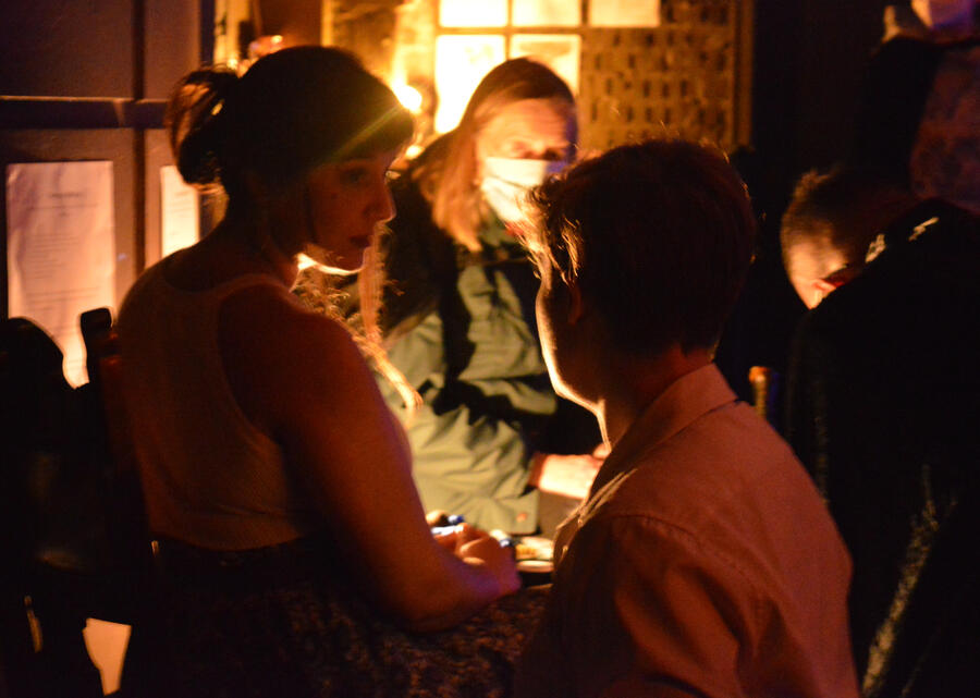 Moody promotional shot of Michelle Kelly in a dark tavern