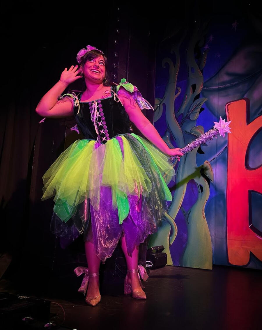 Immersive theatre shot, Michelle Kelly gestures while enthusiastically explaining something