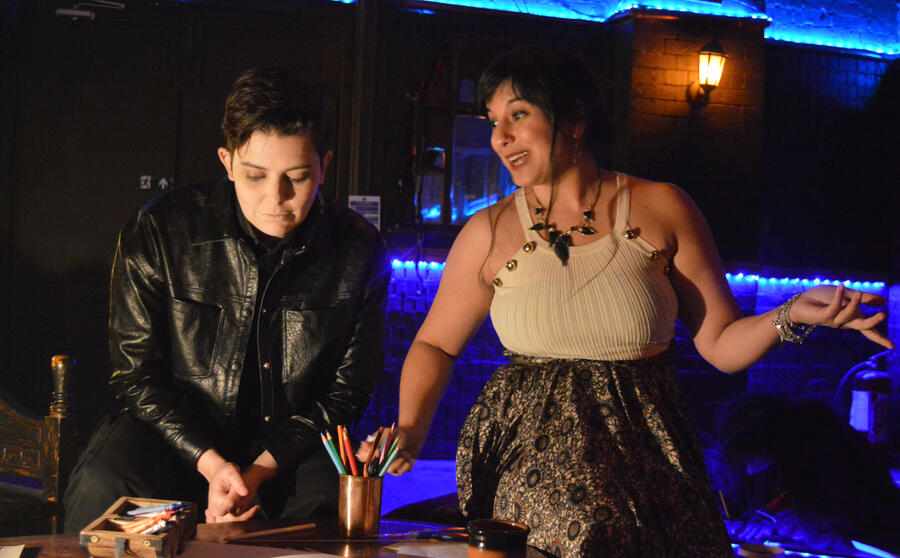 Immersive theatre shot, Michelle Kelly gestures while enthusiastically explaining something