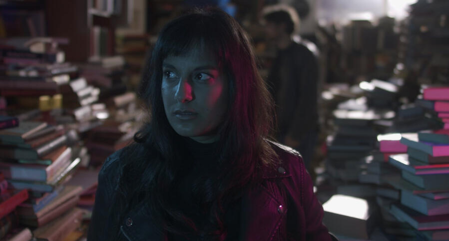 Film still of Michelle Kelly looking around a cluttered bookshop