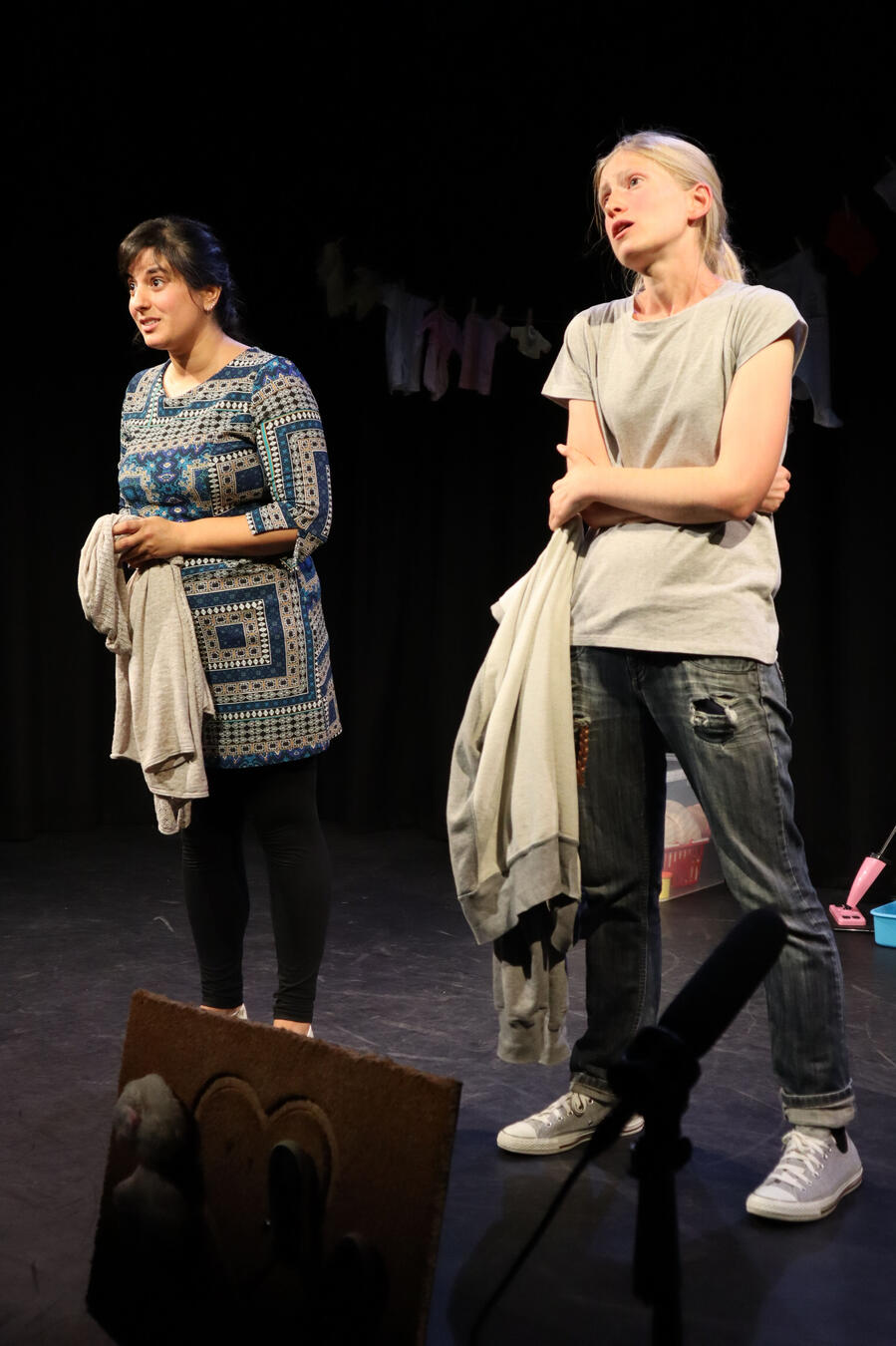 Michelle Kelly smiles as she delivers a monologue on a black box stage